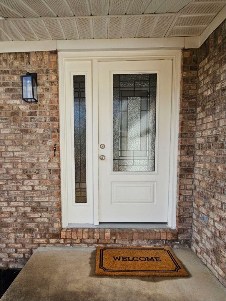 A white front door with a sidelite